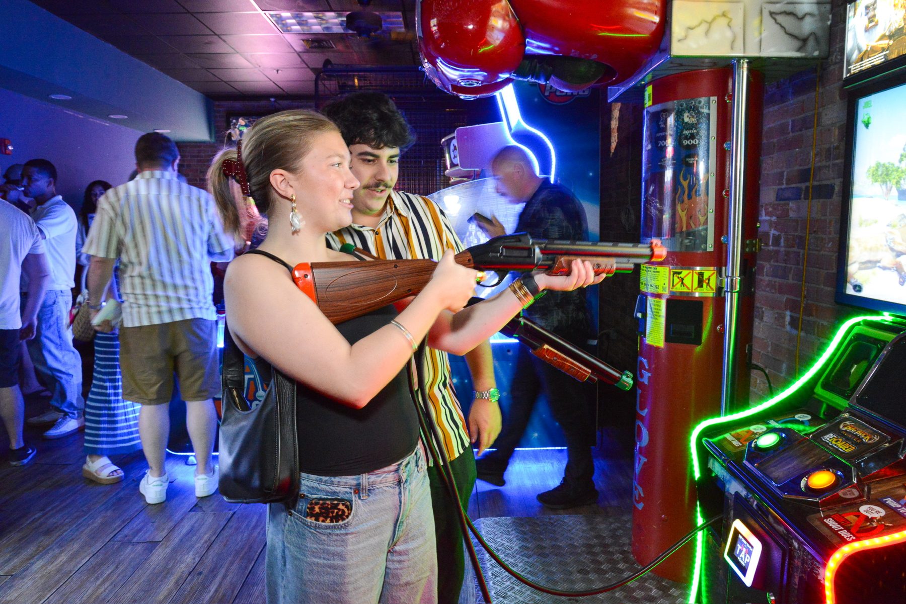 Guests taking aim at a light gun shooting cabinet